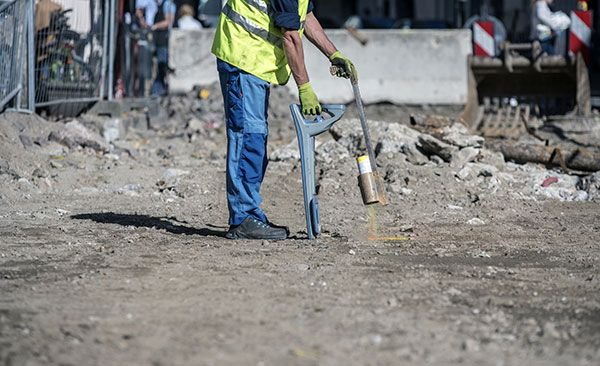 Technician exposing underground services during cable and pipe locating works