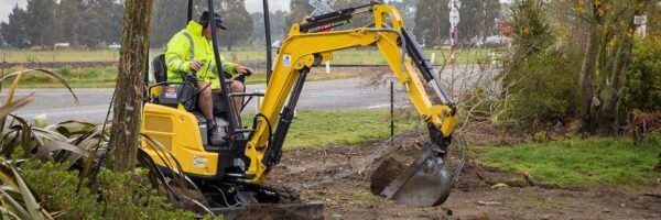 Excavator cutting a cable trench across open ground