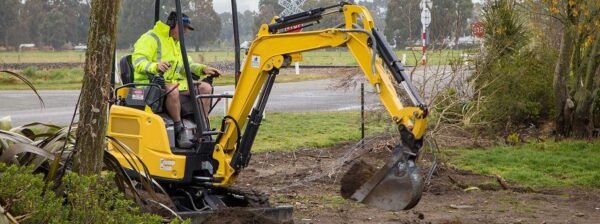 Excavator cutting a cable trench across open ground