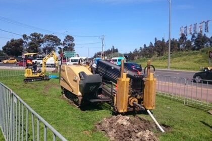 Horizontal directional drilling rig boring beside a road for trenchless cable installation