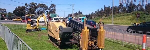 Horizontal directional drilling rig boring beside a road for trenchless cable installation