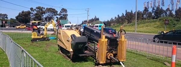Horizontal directional drilling rig boring beside a road for trenchless cable installation