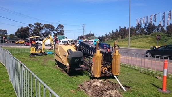 Horizontal directional drilling rig boring beside a road for trenchless cable installation